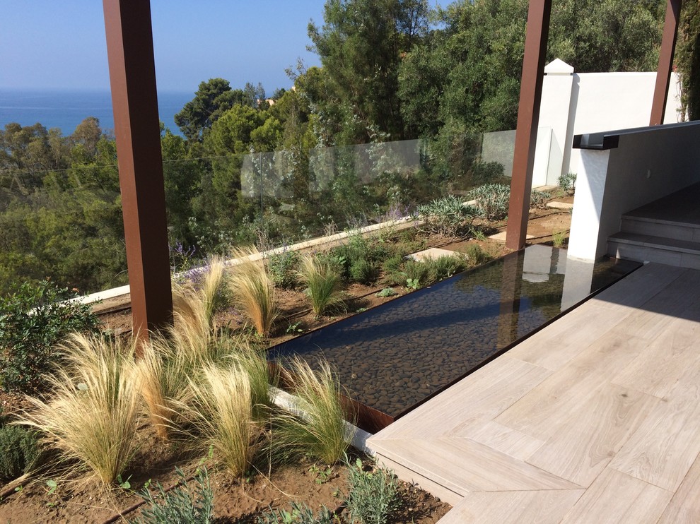 Foto de jardín mediterráneo de tamaño medio en patio trasero con fuente