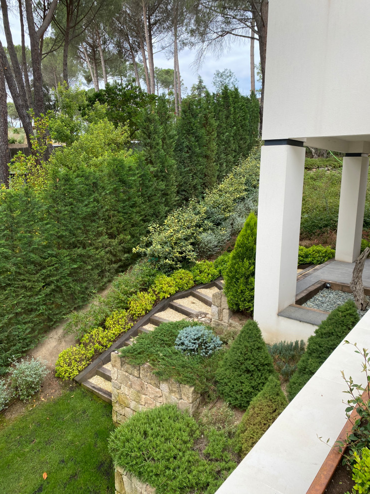 На фото: участок и сад в современном стиле с подъездной дорогой, полуденной тенью и с деревянным забором с
