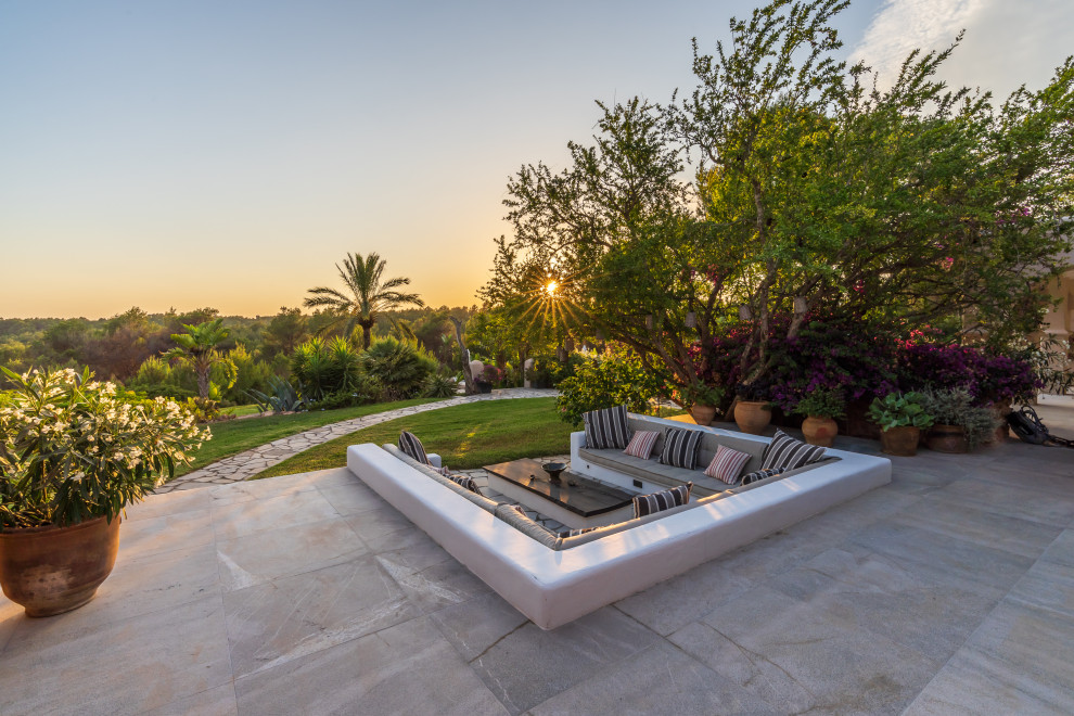 На фото: большой участок и сад в средиземноморском стиле с покрытием из каменной брусчатки с