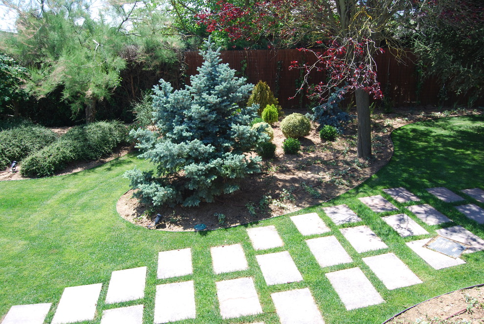 Ejemplo de jardín tradicional renovado grande en patio trasero con exposición parcial al sol y adoquines de piedra natural