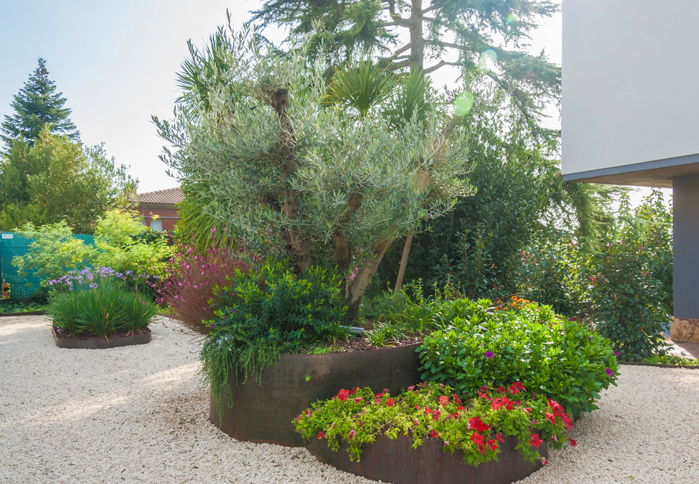 This is an example of a large contemporary partial sun courtyard gravel landscaping in Other.
