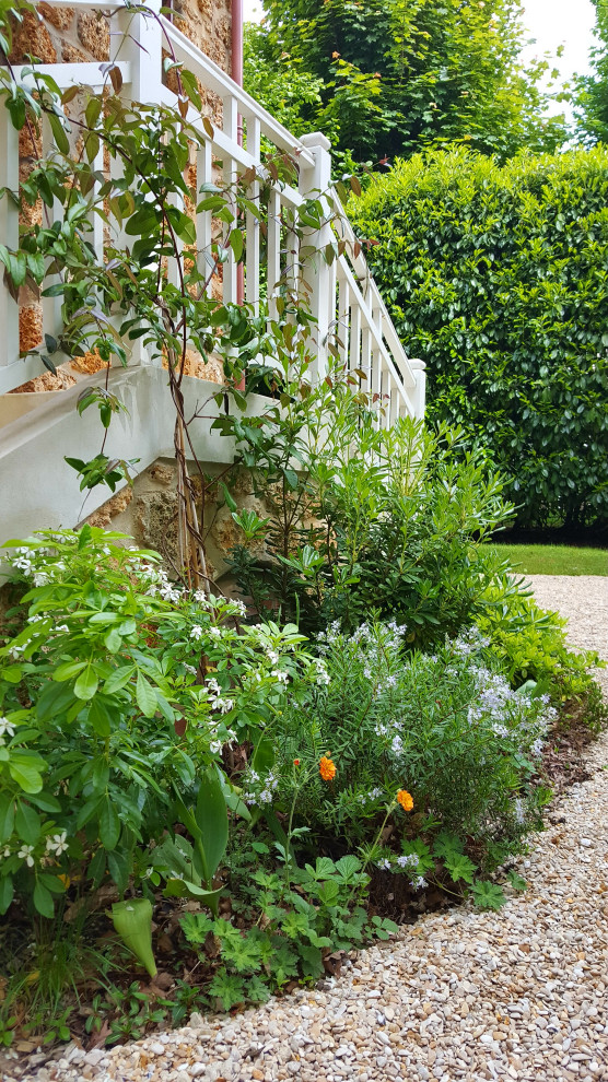 Exempel på en stor shabby chic-inspirerad trädgård i skuggan blomsterrabatt och framför huset på våren, med marktäckning