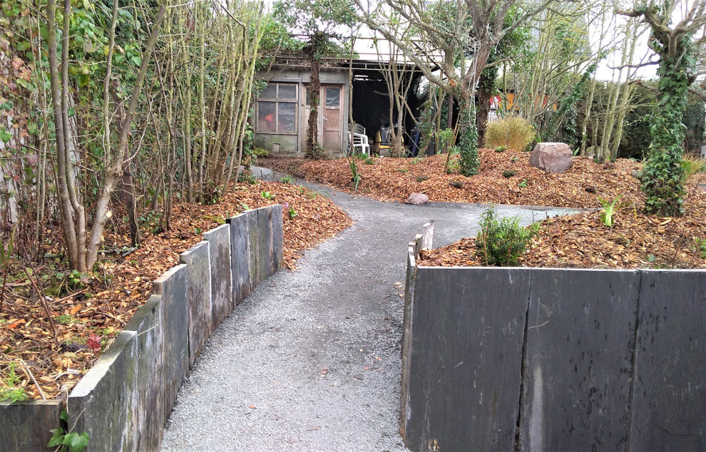 This is an example of a small transitional drought-tolerant and partial sun backyard gravel garden path.