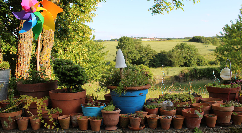 Réalisation d'un jardin en pots champêtre avec une exposition partiellement ombragée.