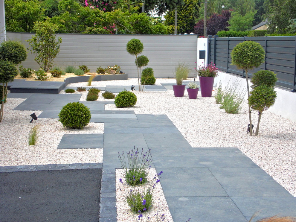 Exemple d'un grand aménagement d'entrée ou allée de jardin avant tendance avec une exposition ensoleillée et du gravier.