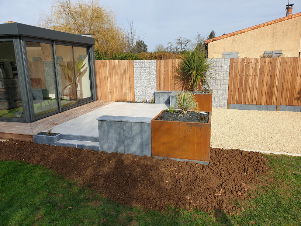 Aménagement d'un petit jardin arrière moderne avec une exposition ensoleillée et une terrasse en bois.