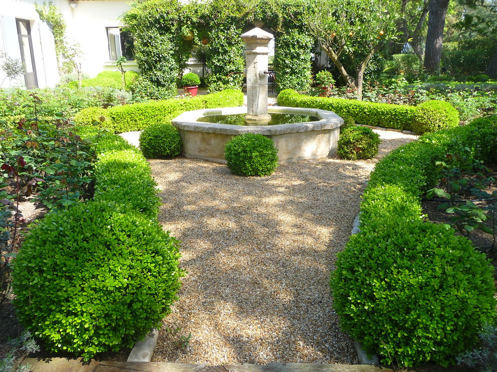 Cette image montre un grand jardin arrière bohème l'été avec du gravier et une exposition partiellement ombragée.