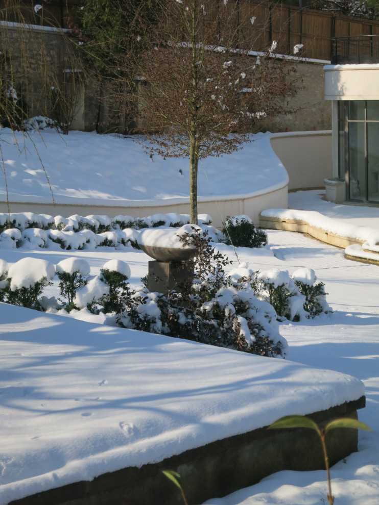 Immagine di un giardino formale shabby-chic style esposto in pieno sole di medie dimensioni e dietro casa in inverno con fontane e pavimentazioni in pietra naturale