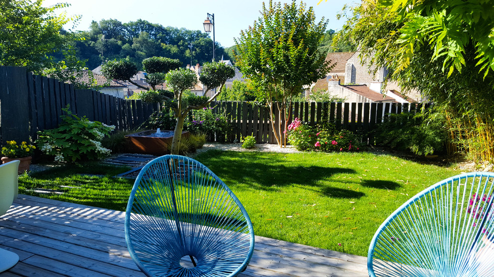 Réalisation d'un petit jardin arrière minimaliste avec une exposition ensoleillée et une terrasse en bois.