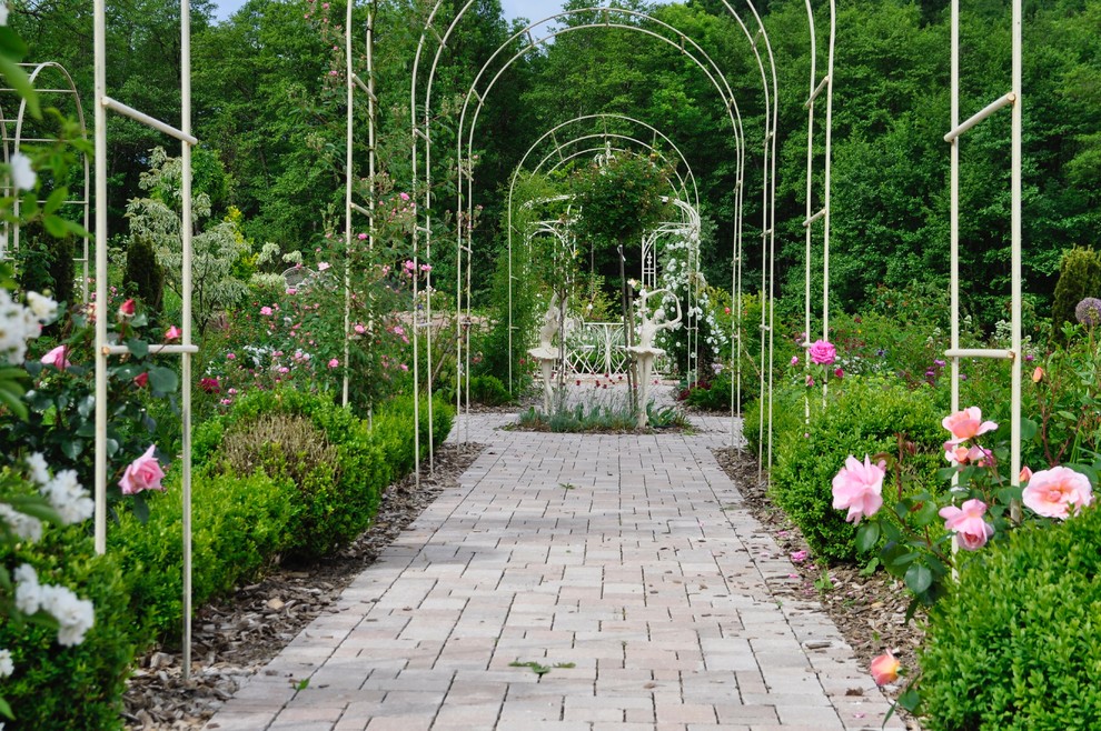 Idées déco pour un grand jardin arrière classique au printemps avec une exposition ensoleillée et des pavés en pierre naturelle.