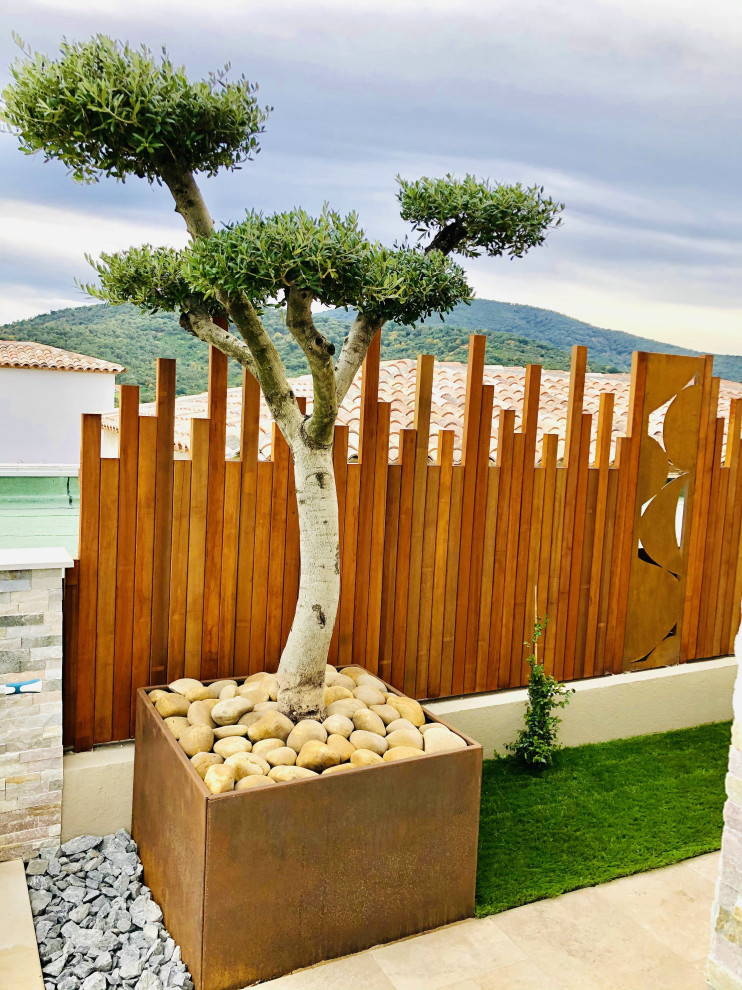 Aménagement d'un jardin contemporain avec des solutions pour vis-à-vis et une clôture en bois.
