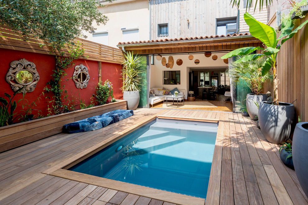 Photo of a small mediterranean courtyard partial sun garden in Bordeaux with a potted garden and decking.