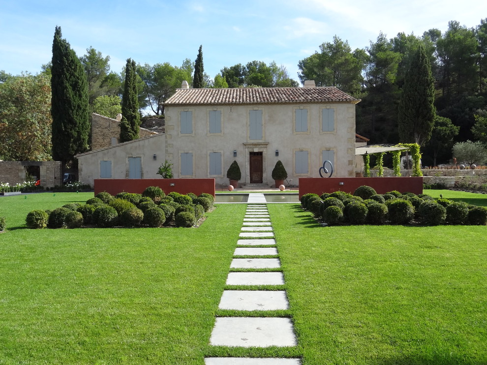 Foto di un ampio giardino classico esposto in pieno sole dietro casa con un ingresso o sentiero e pavimentazioni in cemento