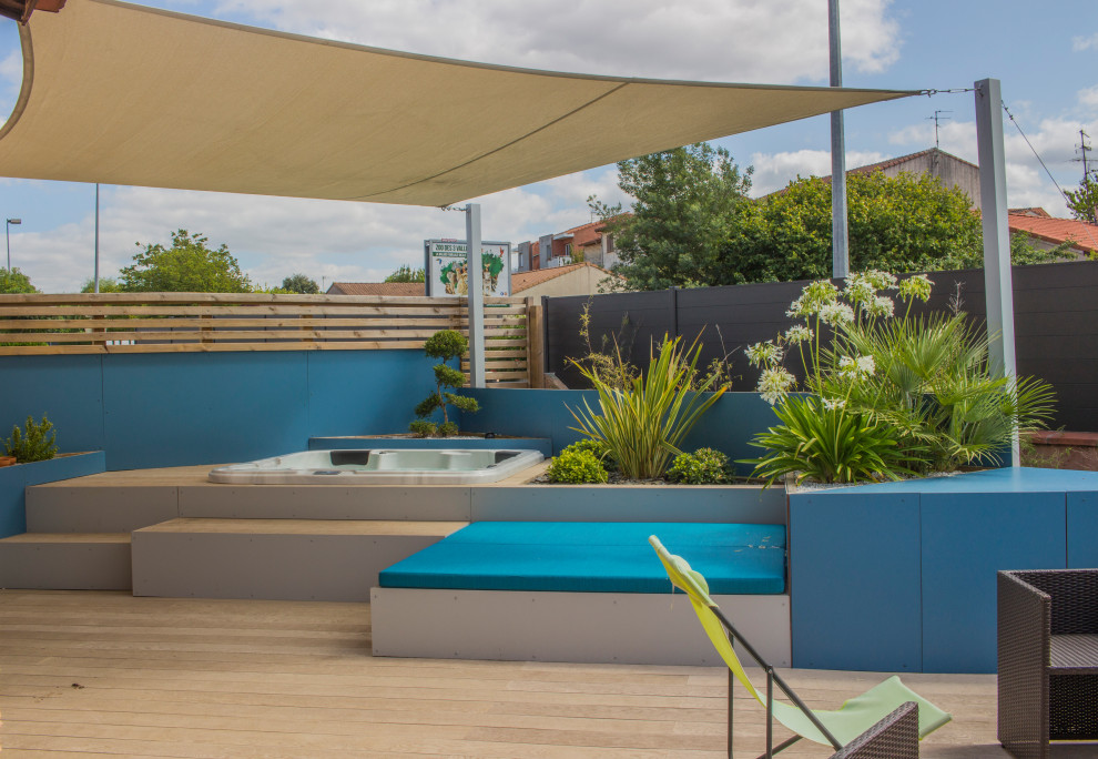 Cette image montre un jardin surélevé arrière minimaliste de taille moyenne et l'été avec une exposition ensoleillée et une terrasse en bois.
