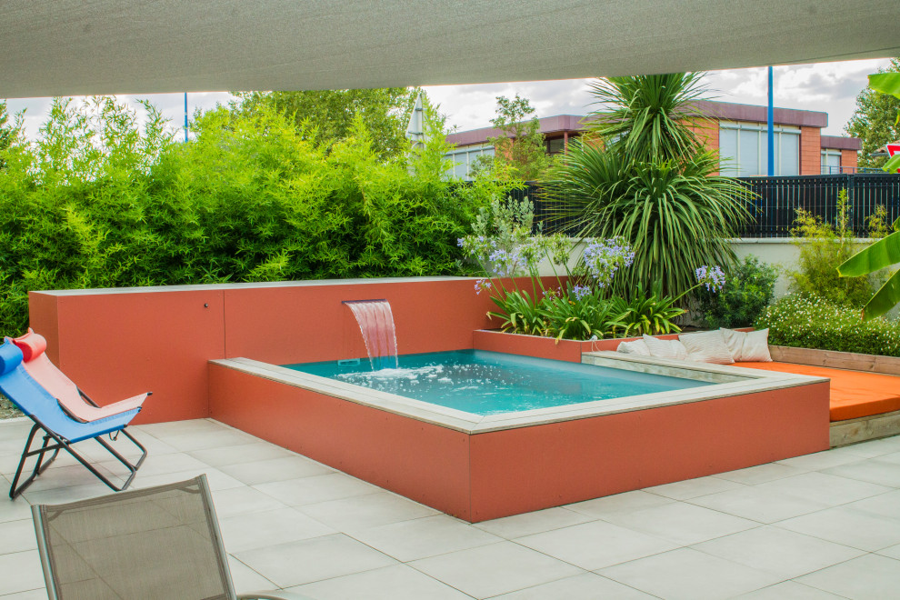Imagen de piscina tropical pequeña en patio trasero