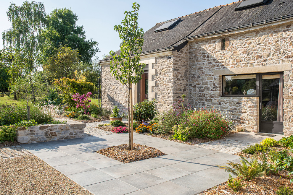 Esempio di un giardino country esposto a mezz'ombra di medie dimensioni e davanti casa in primavera con sassi e rocce e pavimentazioni in pietra naturale