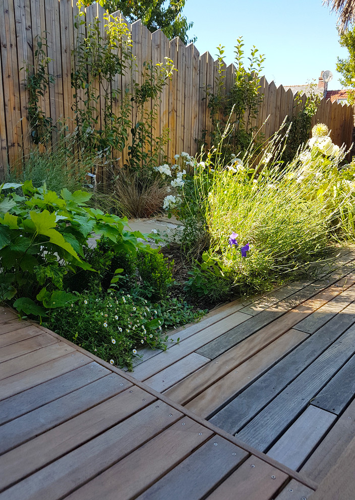 Idée de décoration pour un jardin latéral champêtre de taille moyenne et au printemps avec une exposition partiellement ombragée et une terrasse en bois.