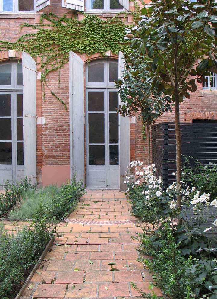 Ispirazione per un piccolo giardino formale classico esposto a mezz'ombra in cortile in estate con pavimentazioni in mattoni