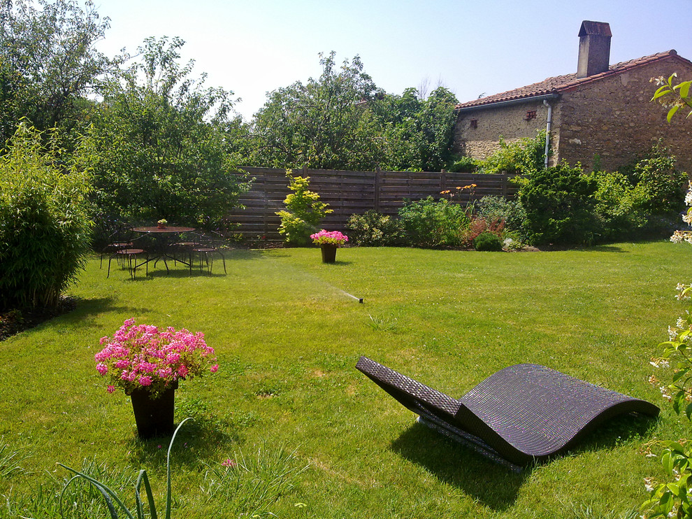 Immagine di un giardino country esposto in pieno sole di medie dimensioni e davanti casa con pavimentazioni in pietra naturale