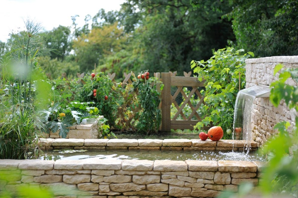 Bild på en lantlig formell trädgård, med en köksträdgård och naturstensplattor