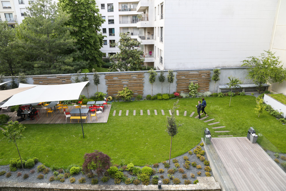 Idée de décoration pour un grand jardin à la française arrière design au printemps avec une exposition partiellement ombragée, un chemin, une terrasse en bois et une clôture en bois.