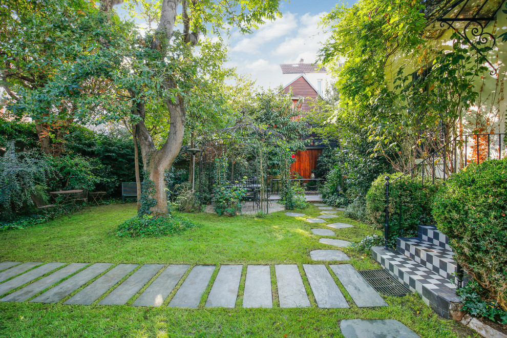 Foto de camino de jardín tradicional renovado grande en primavera en patio delantero con jardín francés, exposición parcial al sol, adoquines de piedra natural y con piedra