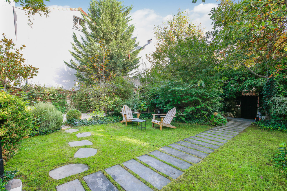 Exemple d'un grand jardin avant chic au printemps avec une exposition partiellement ombragée, des pavés en pierre naturelle et une clôture en pierre.