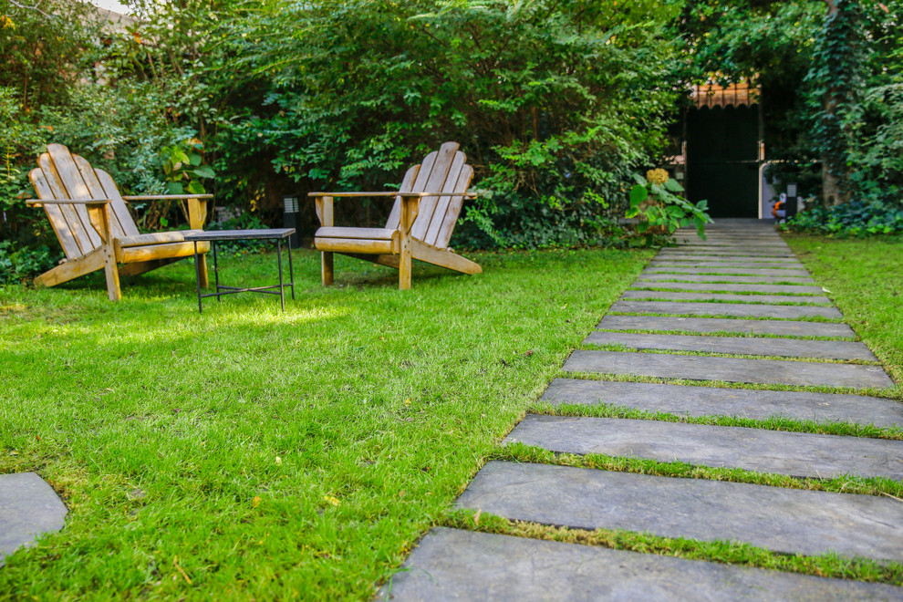 Imagen de camino de jardín tradicional renovado grande en primavera en patio delantero con jardín francés, exposición parcial al sol, adoquines de piedra natural y con piedra