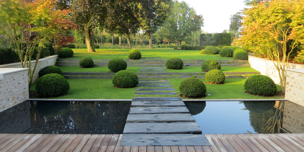 Cette photo montre un grand jardin moderne avec un point d'eau, une exposition ombragée, une pente, une colline ou un talus et des pavés en pierre naturelle.