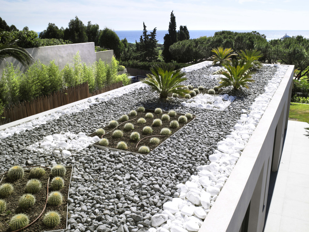 Esempio di un giardino minimal esposto in pieno sole di medie dimensioni e sul tetto con sassi e rocce e recinzione in pietra