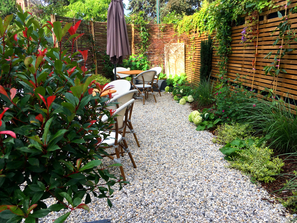 Foto de jardín tradicional renovado de tamaño medio en verano en patio delantero con jardín francés, exposición parcial al sol, adoquines de piedra natural y parterre de flores
