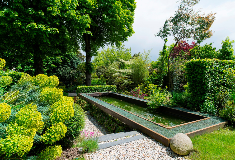 Réalisation d'un jardin à la française méditerranéen avec un bassin et du gravier.