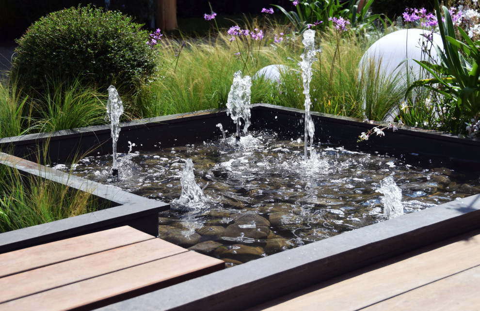 Modelo de jardín minimalista pequeño con estanque, exposición total al sol y entablado