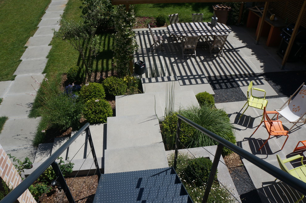 Exemple d'un jardin sur cour tendance avec des pavés en béton.