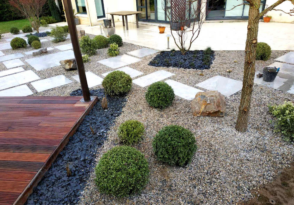 Cette image montre un jardin design de taille moyenne avec des pavés en pierre naturelle.