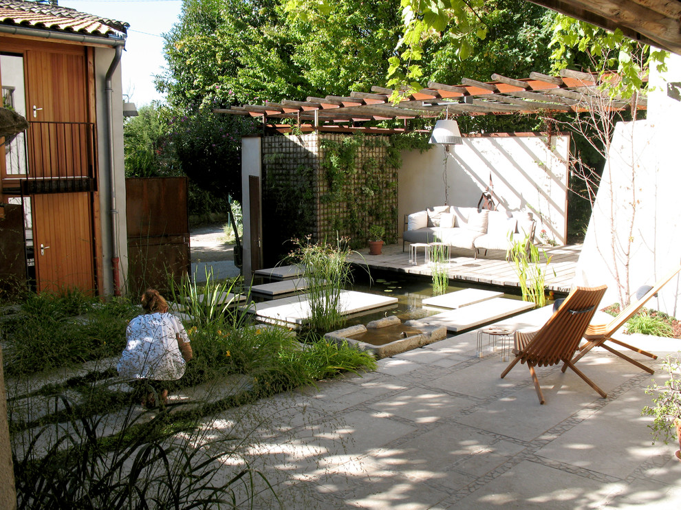Photo of a small modern partial sun garden for summer in Lyon with a water feature.