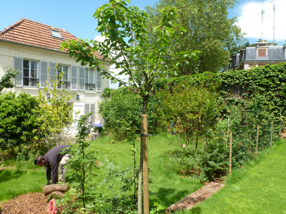 Immagine di un piccolo giardino country esposto in pieno sole dietro casa in estate con pacciame