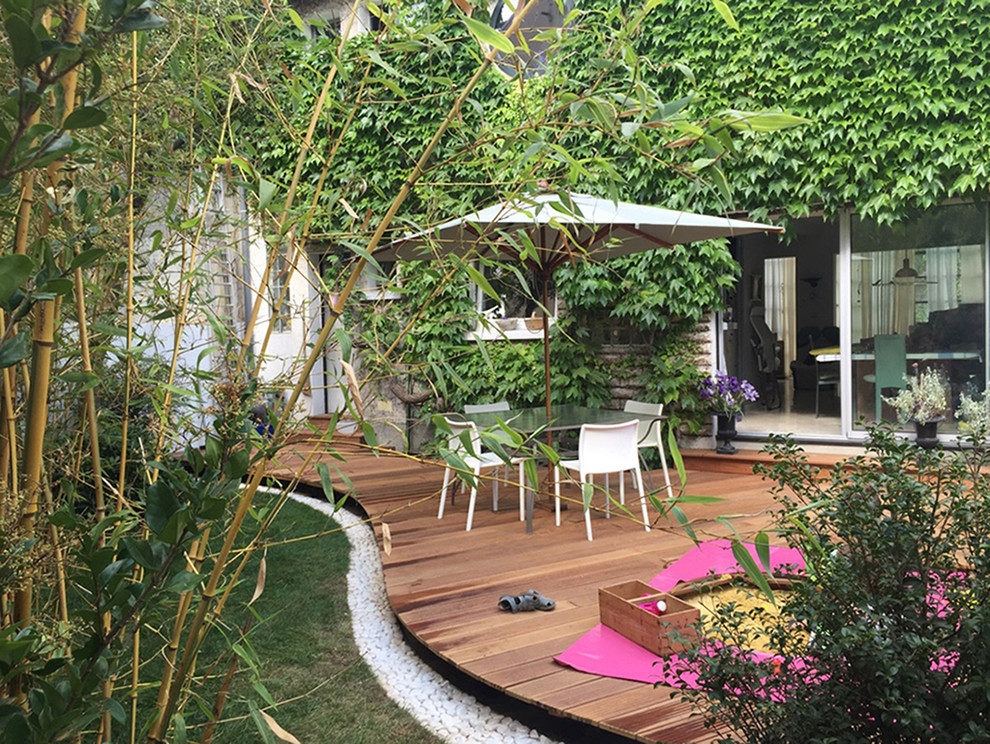 Ejemplo de jardín contemporáneo de tamaño medio en patio trasero con exposición total al sol y entablado