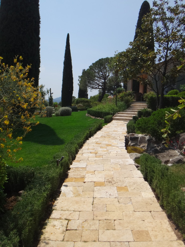 Ejemplo de camino de jardín mediterráneo grande en ladera con exposición total al sol y adoquines de piedra natural