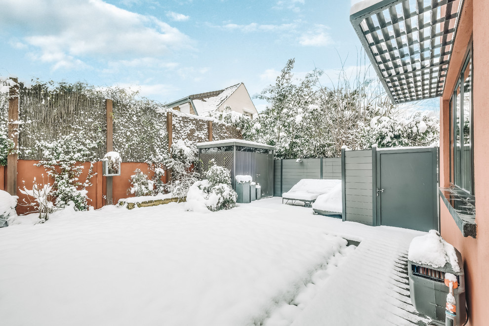 Modelo de jardín contemporáneo grande en invierno en patio lateral con con metal