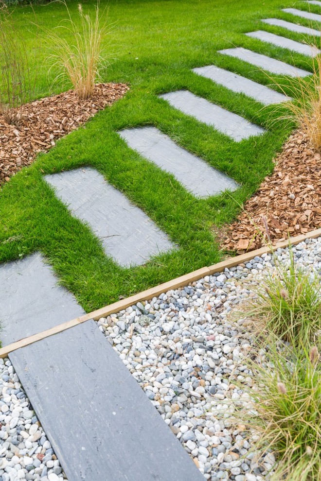 Cette image montre un grand aménagement d'entrée ou allée de jardin avant design au printemps avec une exposition ensoleillée et des pavés en pierre naturelle.