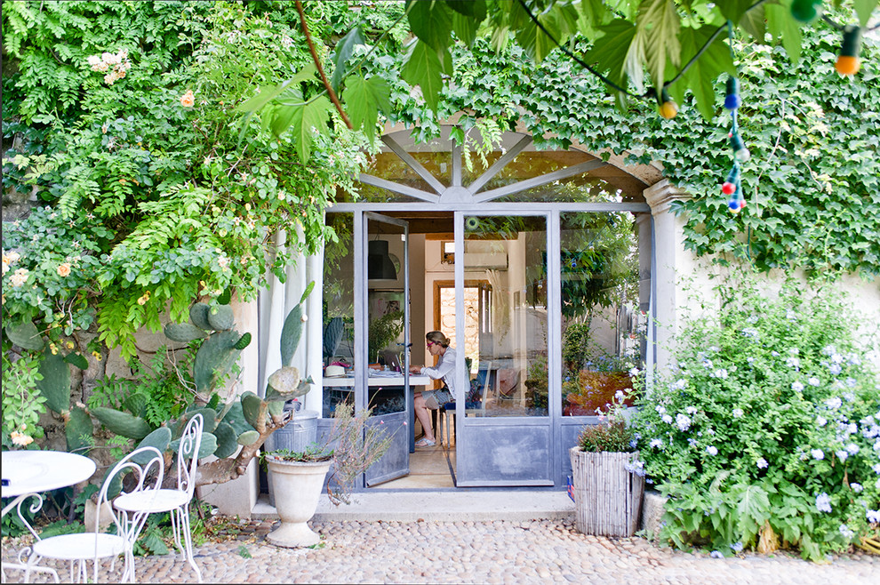 Schattiger, Mittelgroßer Mediterraner Garten im Sommer, hinter dem Haus mit Natursteinplatten und Kübelpflanzen in Montpellier