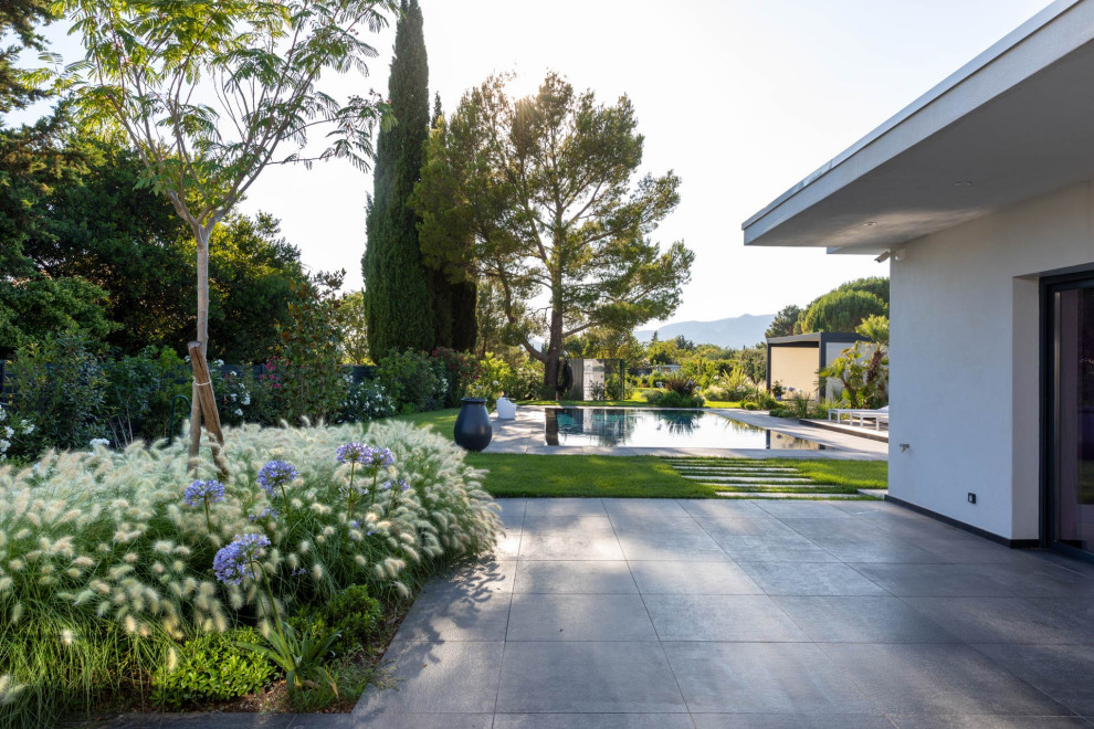 Esempio di una grande aiuola design esposta in pieno sole dietro casa con pavimentazioni in pietra naturale
