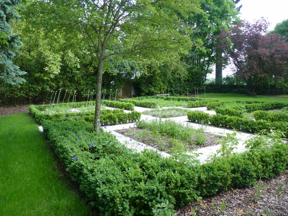 Foto de jardín actual de tamaño medio en verano en patio trasero con jardín francés, huerto, exposición parcial al sol y adoquines de piedra natural