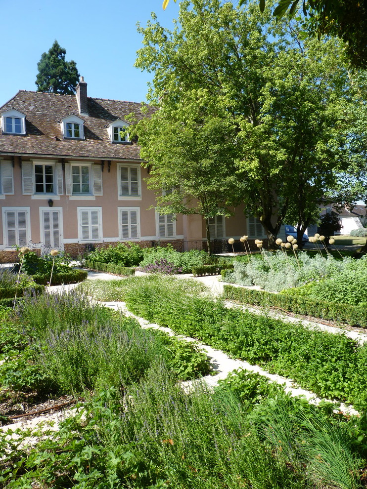 Bild på en mellanstor vintage trädgård i full sol på sommaren, med en köksträdgård och naturstensplattor