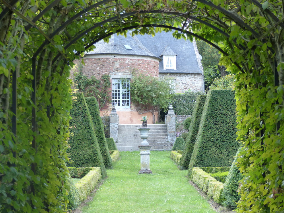 Large classic courtyard formal partial sun garden for summer in Toulouse with a garden path.