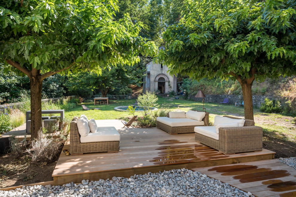 Immagine di un grande giardino mediterraneo esposto in pieno sole davanti casa in estate con pedane