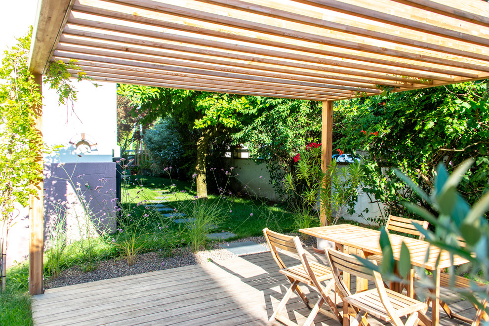 Réalisation d'un jardin arrière champêtre de taille moyenne et l'été avec une exposition partiellement ombragée et une terrasse en bois.