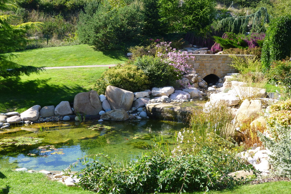 This is an example of a large mediterranean partial sun backyard water fountain landscape in Paris for summer.