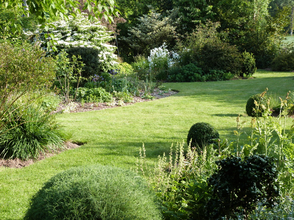Imagen de camino de jardín clásico grande en patio trasero con exposición parcial al sol